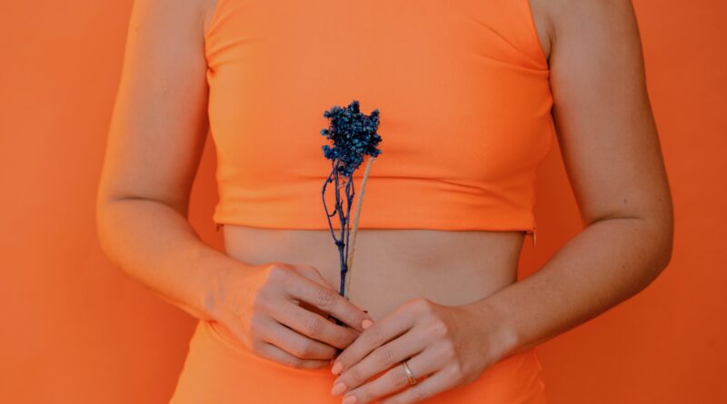 girl holding a flower toward her belly